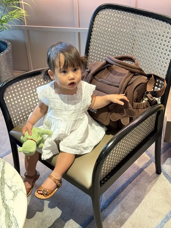 Toddler next to a Midnight Brownie bag on a chair
