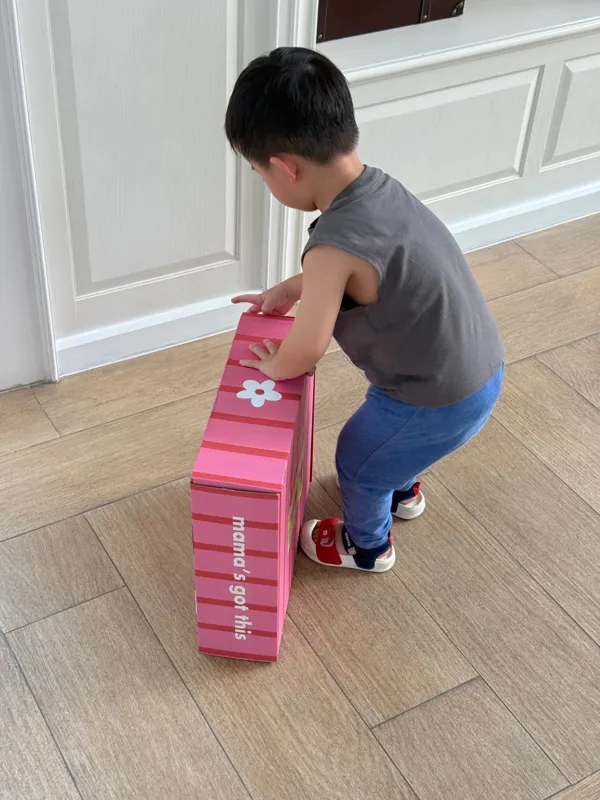 Child with a striped Flying Mama box