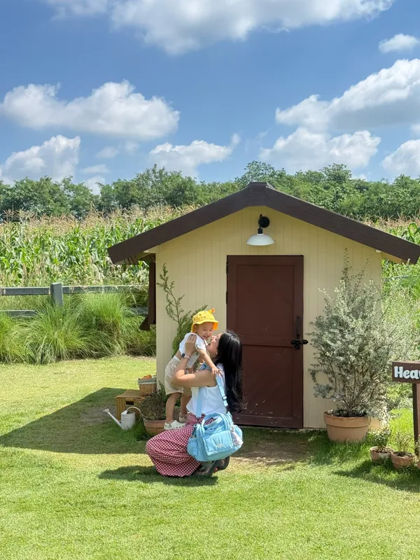 Mom lifting her baby with a Bubblegum Blue bag