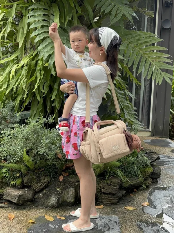 Mom carrying her son with an Oatmilk Latte bag